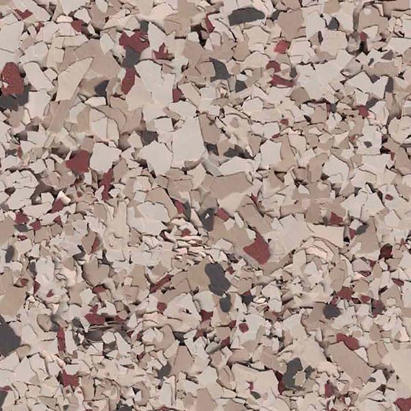 Close-up view of a surface covered with beige, white, black, and red flake-like fragments, resembling a decorative epoxy floor coating.